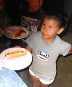 A San JosÃ© girl receives a hot dog at our "block party" at the San Miguel church.
