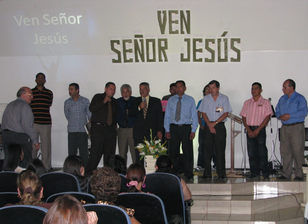 CR pastors being honored at 2012 Costa Rica For Christ national convention. On the left, Terry Hull comes to the stage to pray for these faithful brothers.